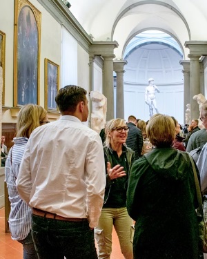 Ljudje v galeriji uporabljajo audioguide za poglobljeno doživetje umetnosti in kulture 